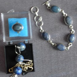 Зууван тал дугуй, бөмбөлөг хэлбэрээр засагдсан хар хөх өнгөтэй номин шигтгээтэй бугуйвч, ээмэг, бөгжний хослол. 