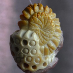 Шар, цагаан, ягаан өнгө алагласан хас чулуугаар сийлж урласан наранцэцэг ба навчс зүүлт /кулон, гоёл чимэглэг/.