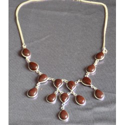 Дусал хэлбэрээр засагдсан, хүрэн бор өнгөтэй опух чулуун шигтгээтэй зүүлт. 