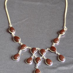 Дусал хэлбэрээр засагдсан, хүрэн бор өнгөтэй опух чулуун шигтгээтэй зүүлт. 