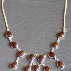 Дусал хэлбэрээр засагдсан, хүрэн бор өнгөтэй опух чулуун шигтгээтэй зүүлт. 